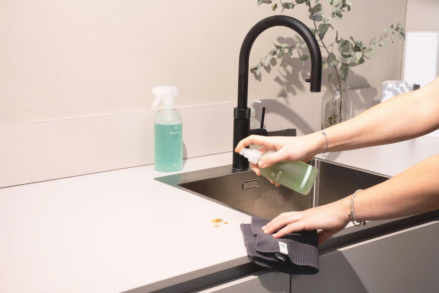 Cleaner wiping down a kitchen sink