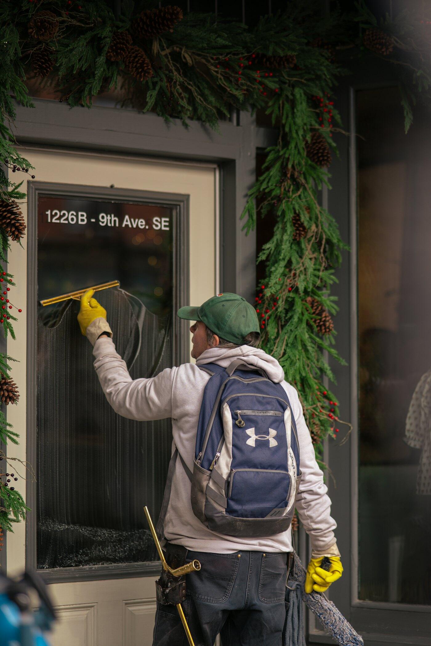 Window cleaner using a squeegee on a shop window